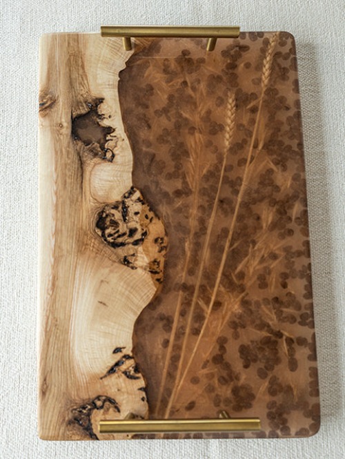 Tabla de servir artesanal con incrustaciones botánicas en resina marrón y asas de latón