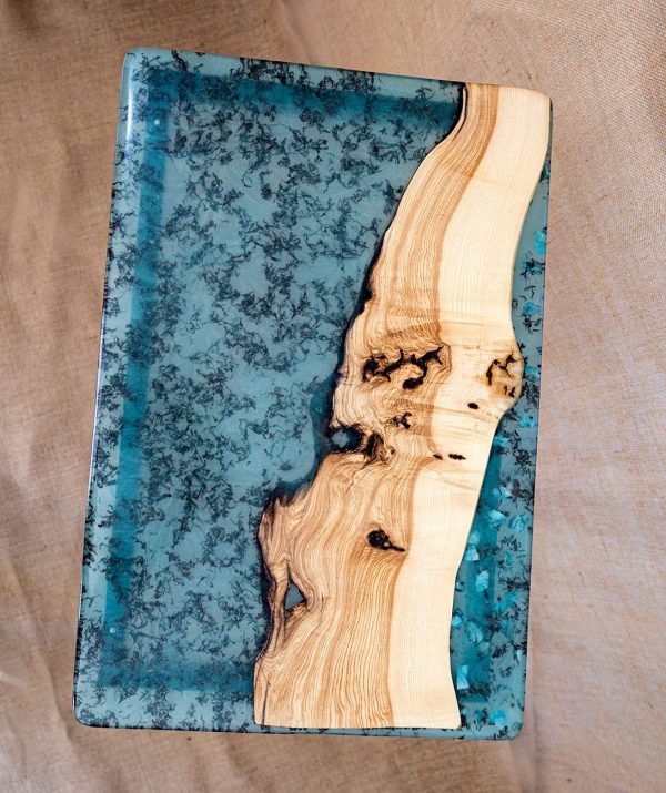 Tabla de resina azul y madera natural con patrón único, ideal para decoración del hogar o arte sustentable.