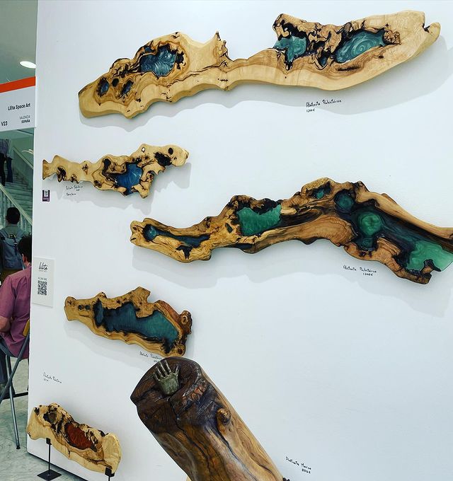 Exposición de obras de arte en madera y resina en una galería, destacando la creatividad y la artesanía