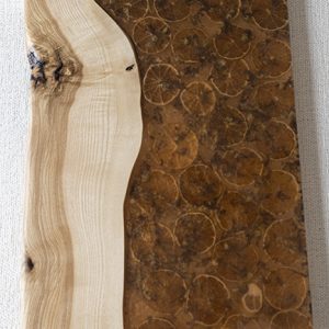 Bandeja de madera artesanal con borde natural y patrones similares a fósiles.