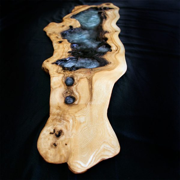 Repisa de madera natural con un diseño fluido y elegante, intercalado con áreas de resina translúcida y negra.