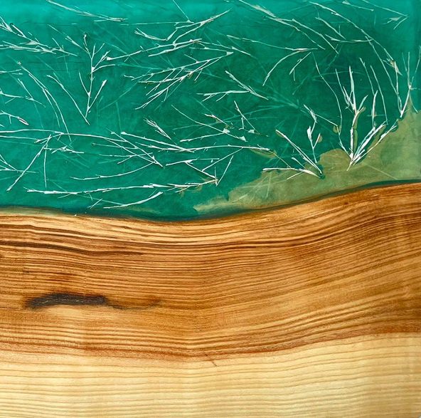 Arte en madera y resina con diseño que asemeja un paisaje acuático