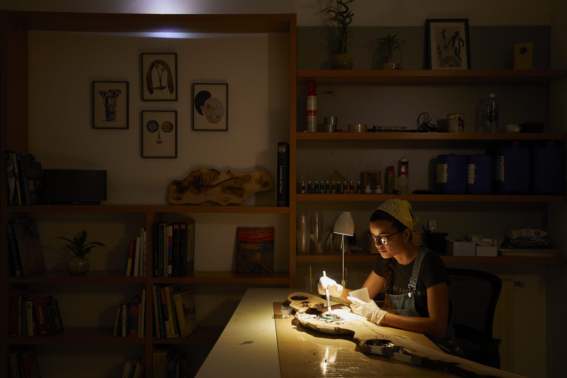 Artista trabajando meticulosamente en un proyecto de arte en madera en su estudio