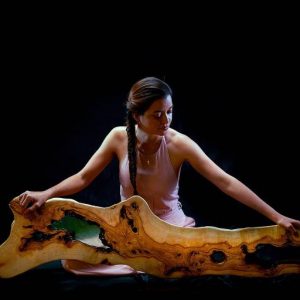 La artista y su lienzo de madera, una fusión de contemplación y creación artística.